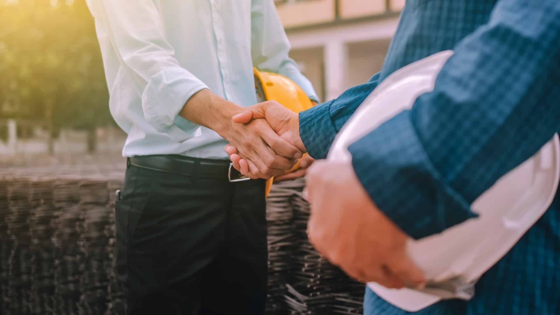 Closeup hand Engineer shake hands agree success project at construction work place