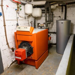 Old oil heating system with oil tank and hot water tank in the basement of a family house - heating with fossil fuels